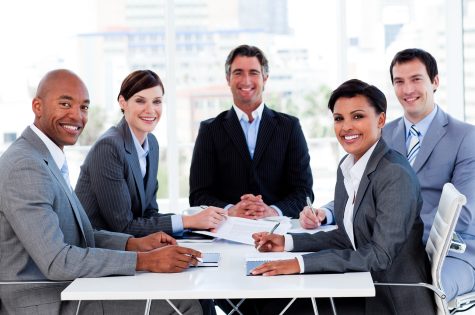 Business group showing ethnic diversity in a meeting smiling at the camera